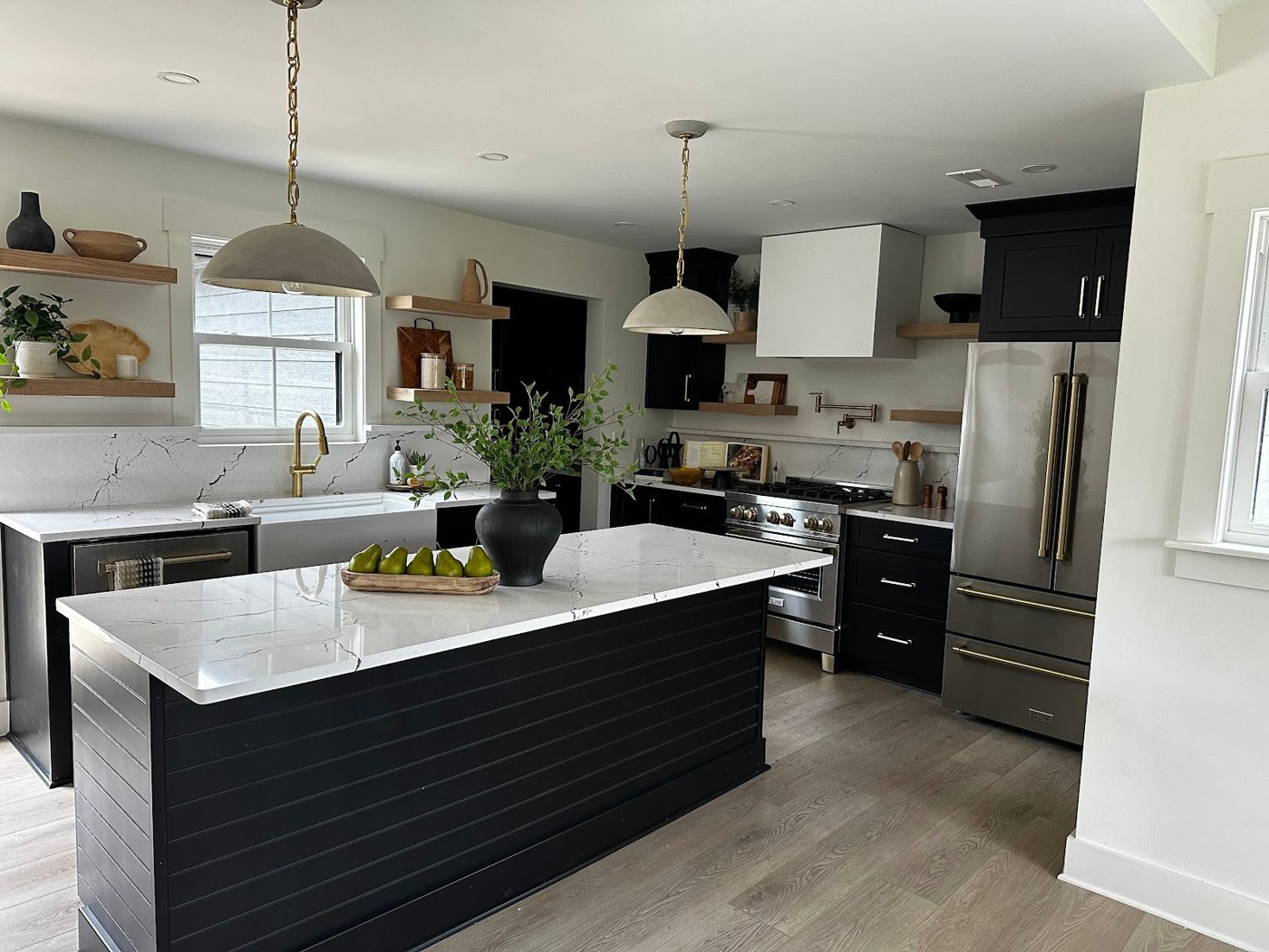 BlueBridge kitchen project with a dark island, white countertops and pendant lighting